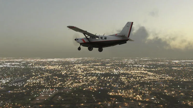 Cessna Caravan turboprop flying over a city glittering with lights at dusk, rendered with REX Atmos CORE atmospherics in Microsoft Flight Simulator 2024