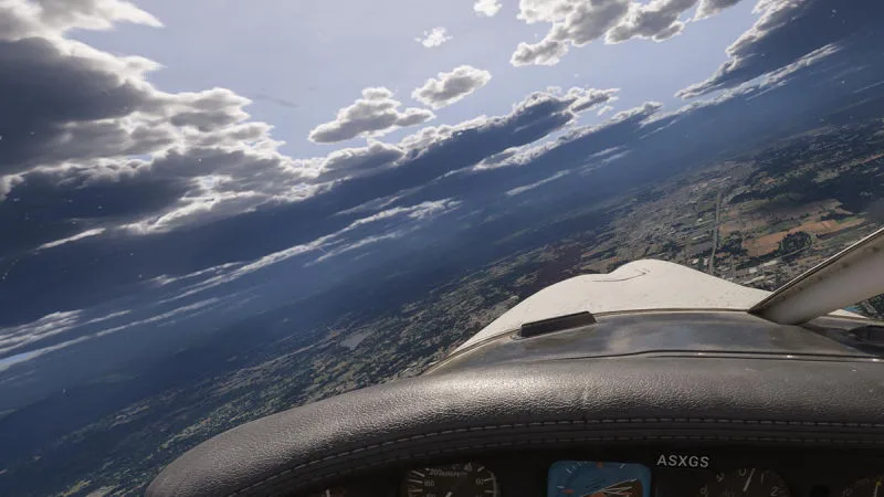 Cessna cockpit banking over farmland beneath dramatic layered clouds, REX Atmos CORE in Microsoft Flight Simulator 2024
