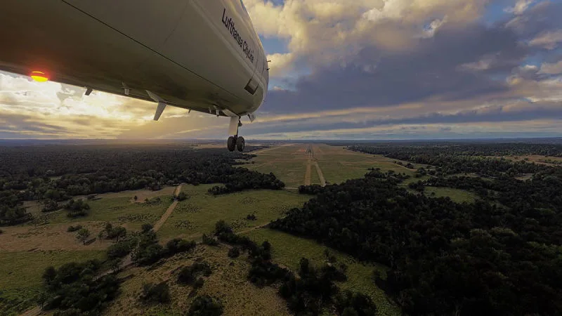 Lufthansa CityLine jet on final approach over green countryside to a runway, REX Atmos CORE in Microsoft Flight Simulator 2024